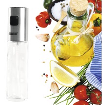 Ölsprüher aus Edelstahl und Glas mit verschiedenen Zutaten im Hintergrund