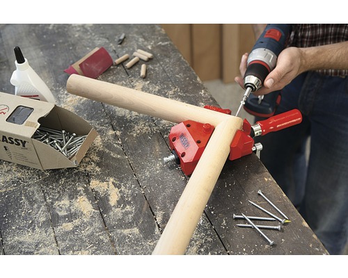 Werkstattszene mit Schraubzwinge, Schrauben, Dübeln und Akkuschrauber zum Holzwerken