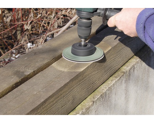 Bohrmaschine mit Schleifscheibe bearbeitet Holzbrett