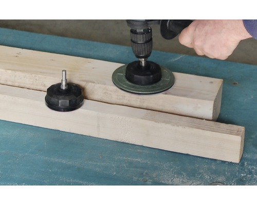 Eine Bohrmaschine mit Schleifscheibe wird auf Holz verwendet.