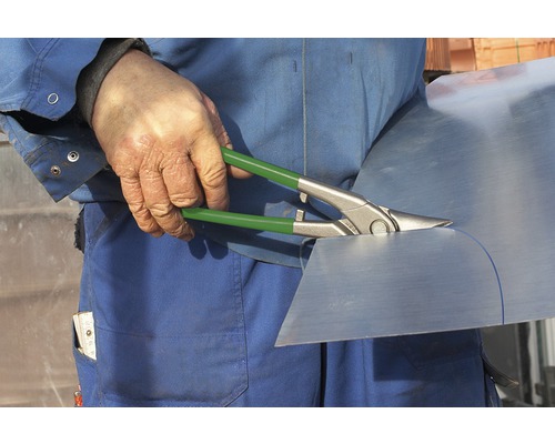 Handwerker schneidet Blech mit Blechschere