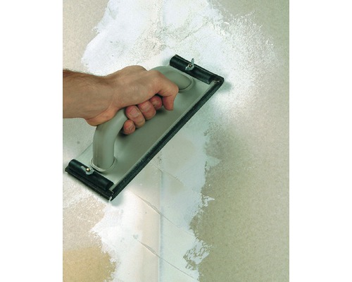 Hand mit Reibebrett beim Verputzen einer Wand