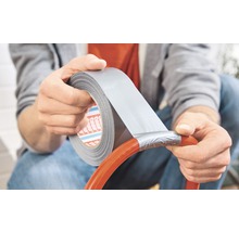 Person repariert einen Schlauch mit Gewebeband