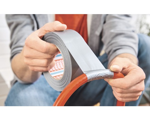 Person repariert einen Schlauch mit Gewebeband