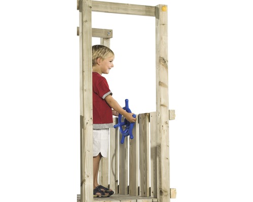 Kind spielt mit einem blauen Steuerrad in einem hölzernen Spielturm.