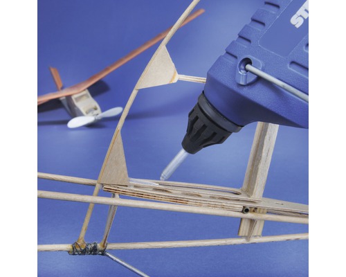 Heißklebepistole beim Verkleben eines Modellflugzeugs