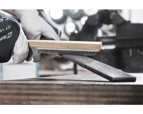 Drahtbürste mit Holzgriff reinigt eine Metallfeile