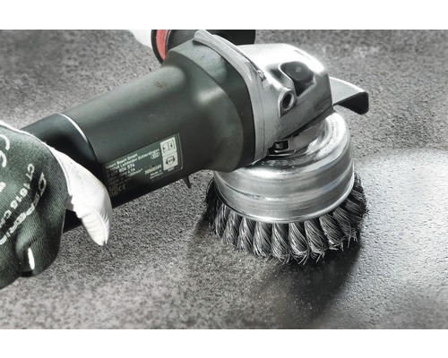 Drahtbürstenaufsatz an einer Schleifmaschine in Verwendung