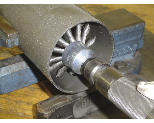 Rohrbürste aus Draht im Einsatz zum Entgraten eines Metallrohrs