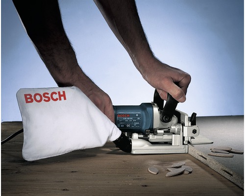 Nutfräsmaschine in Benutzung mit Staubbeutel und Holzdübeln