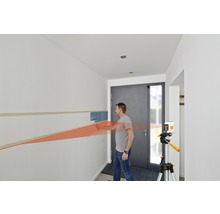 Mann verwendet einen Linienlaser zum Malen einer Wand