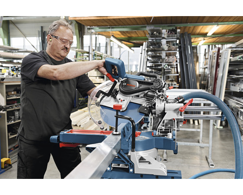 Mann bedient eine Bosch Kapp- und Gehrungssäge in einer Werkstatt.