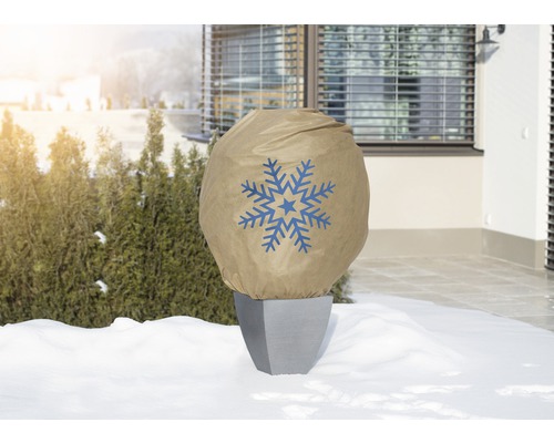 Pflanztopf mit Winterschutzhaube und Schneeflockenmuster im Garten