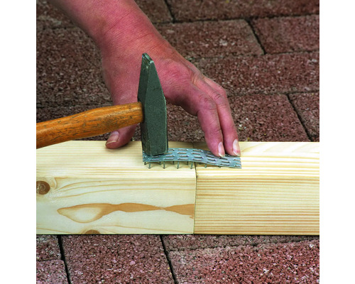 Handwerker befestigt Holz mit einem Hammer und einer Nagelplatte