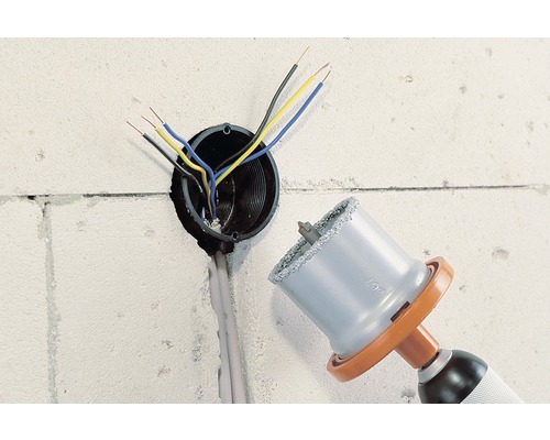 Bohrmaschine mit Lochsäge zum Bohren einer Steckdose in einer Wand