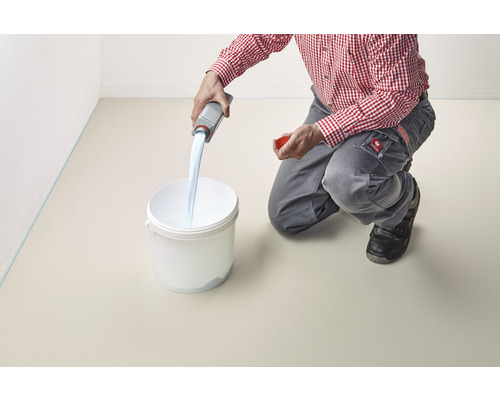 Eine Person gießt eine Flüssigkeit aus einer Flasche in einen Eimer.