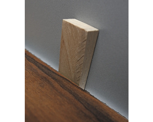 Holzkeil zwischen Laminat und Wand