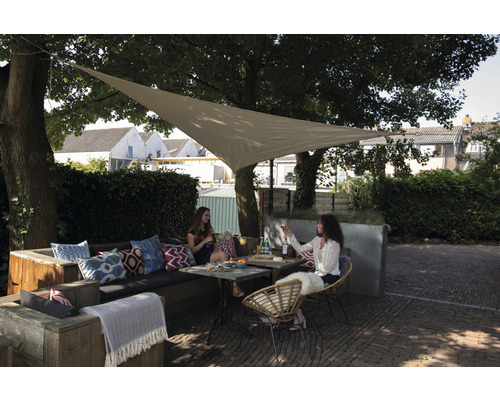 Gartenszene mit Sonnensegel, Sitzgruppe und Personen unter Bäumen