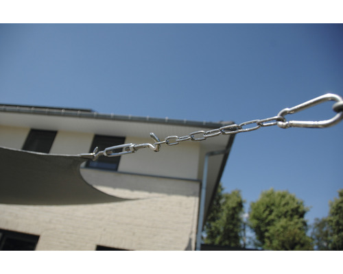 Detailaufnahme einer Sonnensegelbefestigung mit Kette, Spannschloss und Karabinerhaken.
