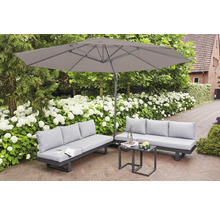 Gartenmöbel-Set mit zwei Sofas, einem Tisch und einem Sonnenschirm im Garten