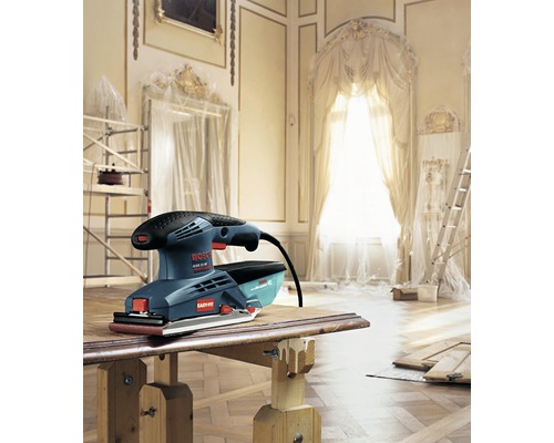 Bosch Logo. Schwingschleifer auf einem Holztisch in einem renovierten Raum.