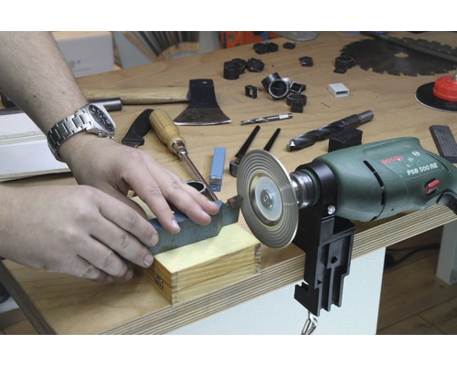 Mann schärft Werkzeug mit einem Schleifwerkzeug von Bosch an einer Werkbank.