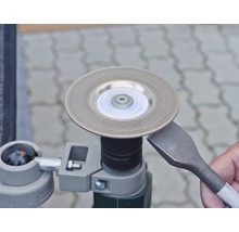 Eine Stechbeitel wird an einer Schleifscheibe geschärft.