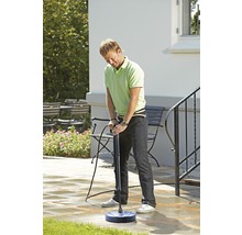 Ein Mann verwendet einen Terrassenreiniger, um Steinplatten zu säubern.