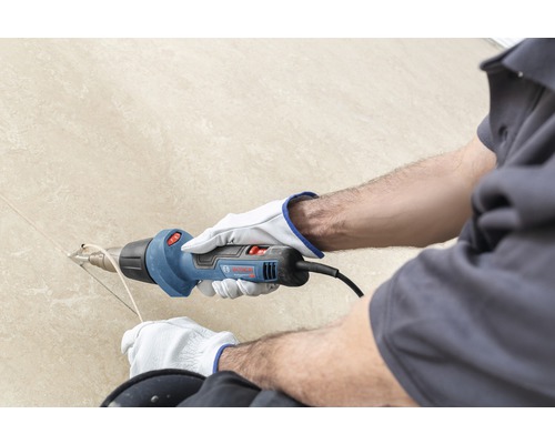 Handwerker verwendet ein Heissluftgebläse von Bosch für Installationsarbeiten