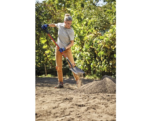 Frau arbeitet mit Spaten im Garten