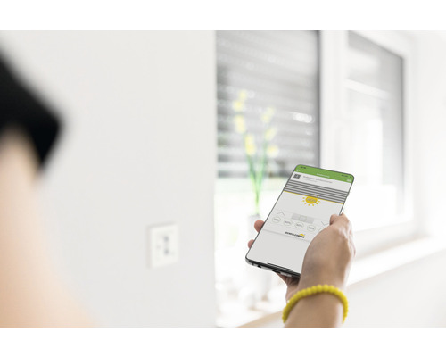 Person steuert Rollladen mit dem Smartphone