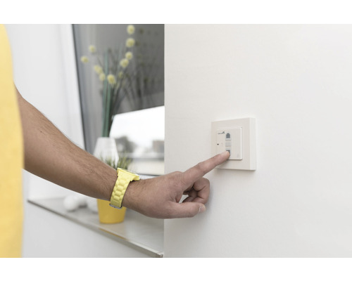 Person bedient einen Lichtschalter an der Wand