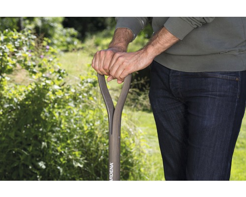 Eine Person hält einen Gardena Spaten im Garten.