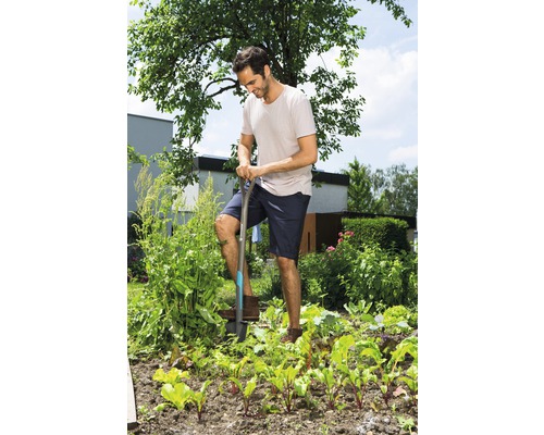 Mann gräbt mit einem Spaten im Gemüsegarten.