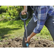 Eine Person gräbt mit einem Spaten im Garten.
