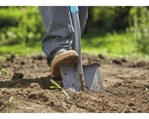 Person sticht Spaten in Gartenerde