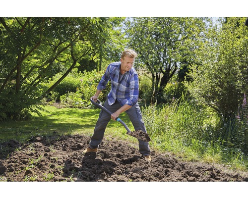 Mann gräbt mit einem Spaten im Garten um.