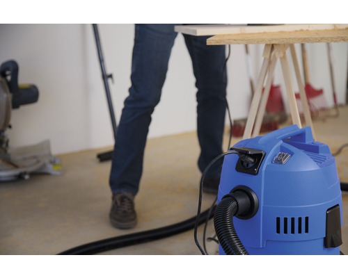 Werkstattsszene mit Staubsauger, Werkbank und Handwerker