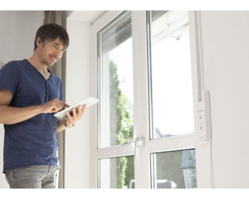 Mann bedient Rollladensteuerung mit Tablet