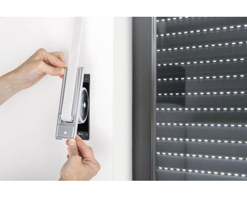 Person montiert einen Gurtwickler für Rollläden.