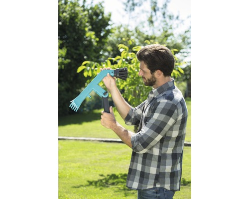 Ein Mann im Garten benutzt einen Obstpflücker zur Ernte.