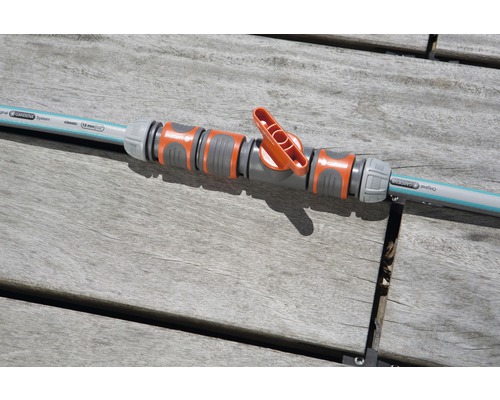 Gardena Regulierventil verbunden mit Gartenschlauch auf einem Holztisch