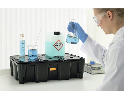 Auffangwanne mit Gefahrensymbol und Laborutensilien im Labor