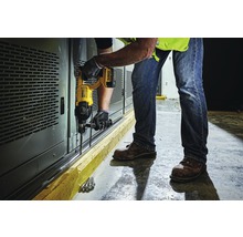 Ein Mann bohrt mit einer Bohrmaschine Löcher in eine Wand.