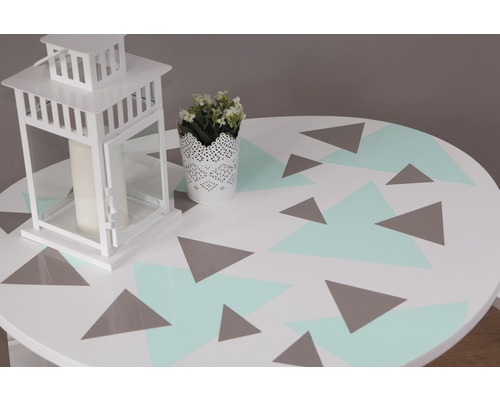 Dekorativer Tisch mit geometrischem Muster, Laterne und Topfpflanze