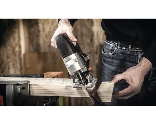 Eine Stichsäge schneidet ein Holzbrett.