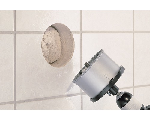 Fliesenbohrer bohrt ein Loch in eine weiße Fliese