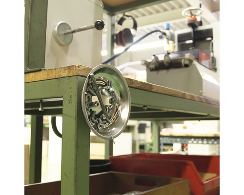 Magnetische Schale mit Schrauben und Muttern an einem Werkstatttisch