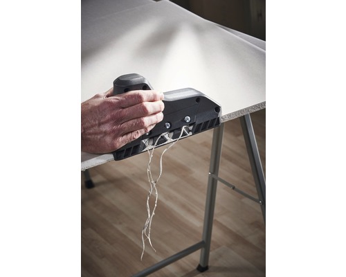 Eine Person verwendet einen Kantenhobel an einer Gipskartonplatte, um eine saubere Kante zu erzeugen.