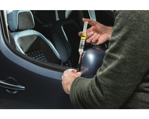 Eine Person repariert eine Autoscheibe mit UHU Turbo Fix Klebstoff